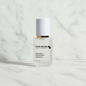Frosted glass bottle of 'Hydra Lotion' with a white cap and gold accent, on a white marble background.