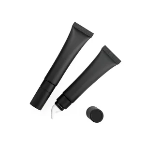 Two sleek matte black tubes, one open revealing a white slanted applicator tip, for private label lip gloss or liquid lipstick.