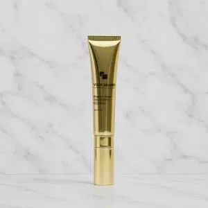 Golden private label eye cream tube with pump applicator, labeled 'BrightEye Cream', on a white marble background.